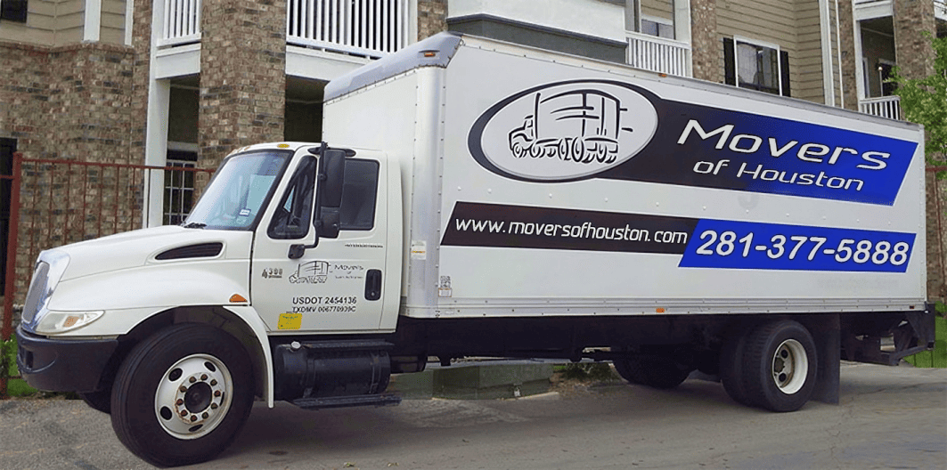 Two movers carefully wrapping furniture for a move.